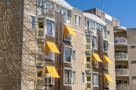 foto van buiten gebouw de rijp met gele zonneschermen