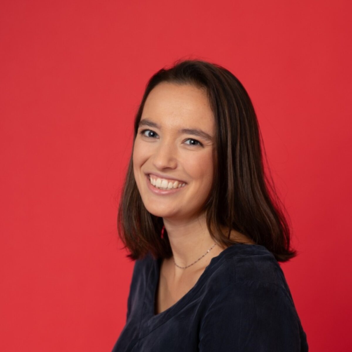 Lachende vrouw voor rode muur