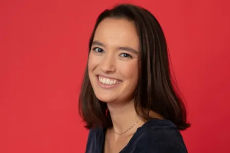 Lachende vrouw voor rode muur