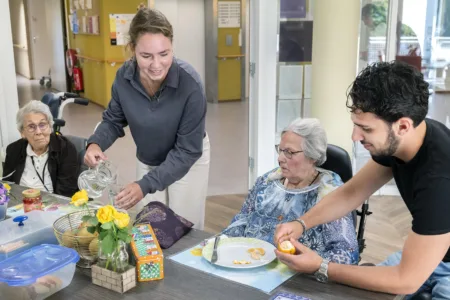 medewerkers helpen clienen aan tafel met eten