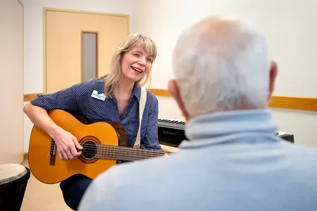 vrouw met gitaar in hand speelt voor client