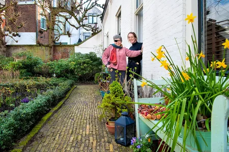 twee vrouwen bij huis in de tuin
