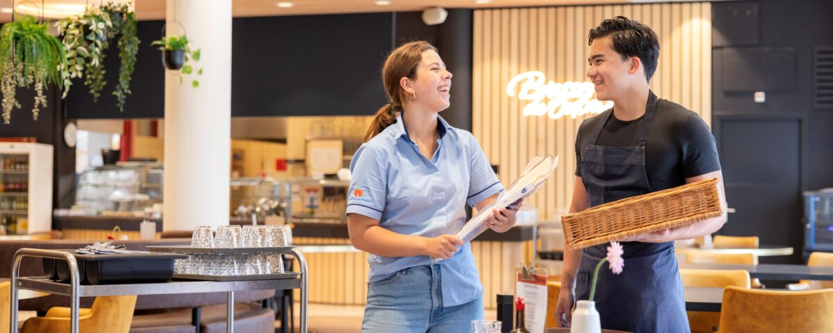 Twee collega's lachend in het restaurant.