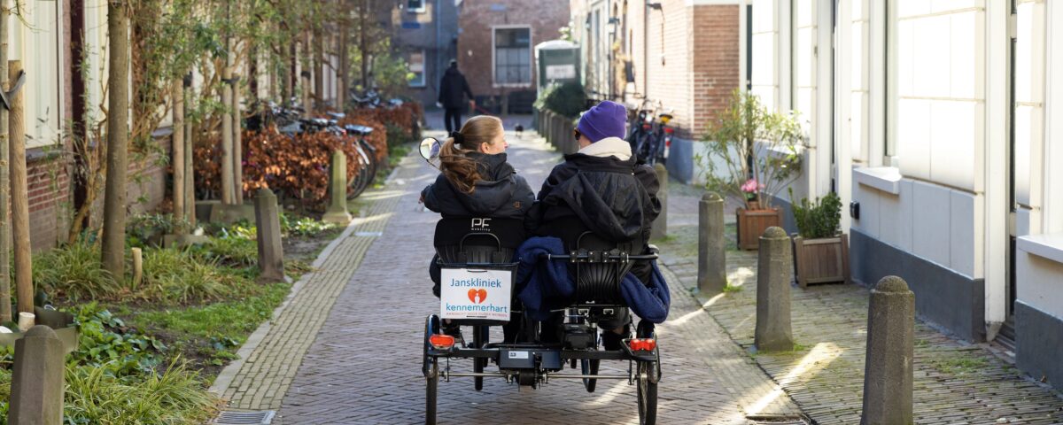 Vrijwilliger en cliënt op de duofiets.