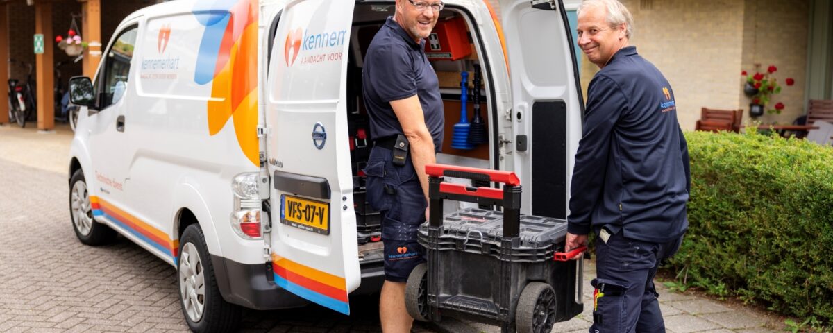 Twee monteurs buiten bij auto