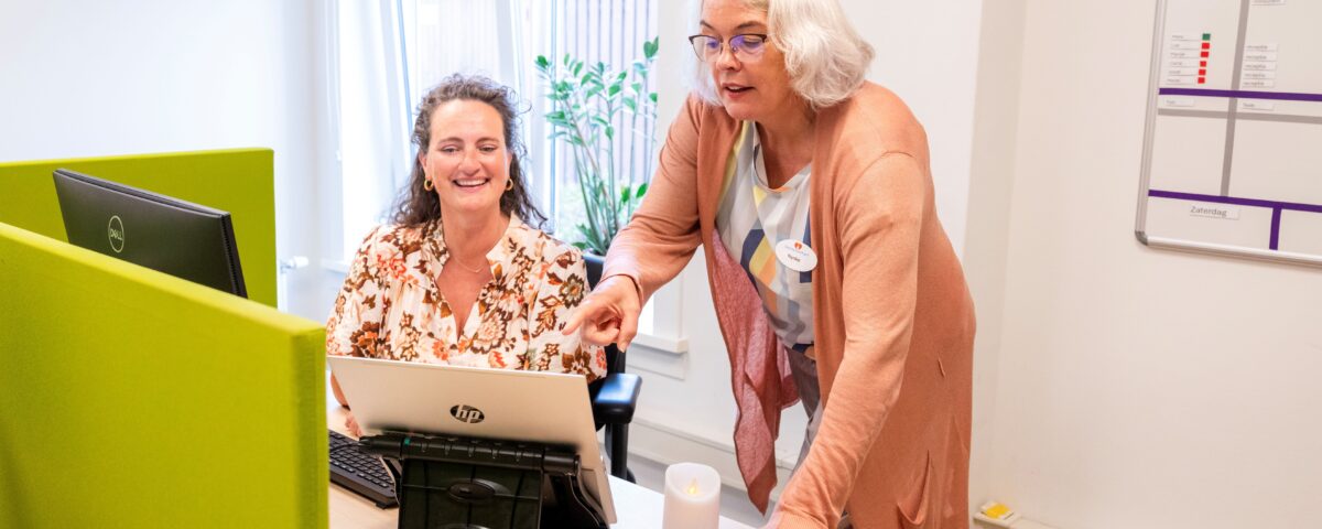 Twee vrouwen kijkend naar laptop