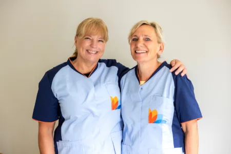 Twee vrouwen lachend in de camera.