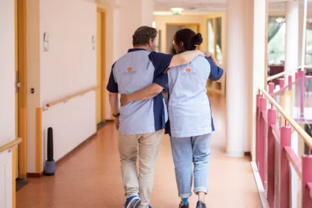 Twee collega's arm in arm.