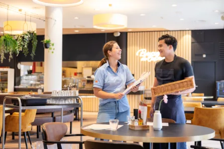 Twee collega's lachend in het restaurant.