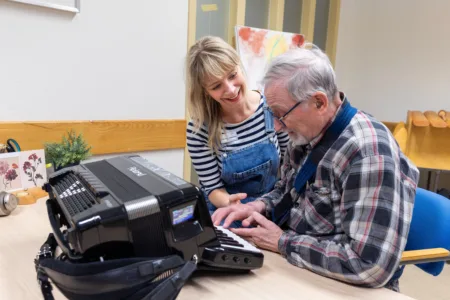 Vrijwilliger samen met cliënt met een keyboard.