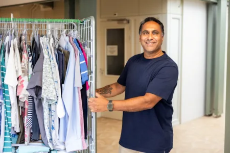 Man bij schone kleding in rek