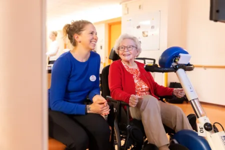 zorgmedewerker naast ouderen vrouw