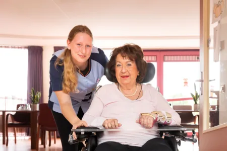 Collega bij cliënt in rolstoel.